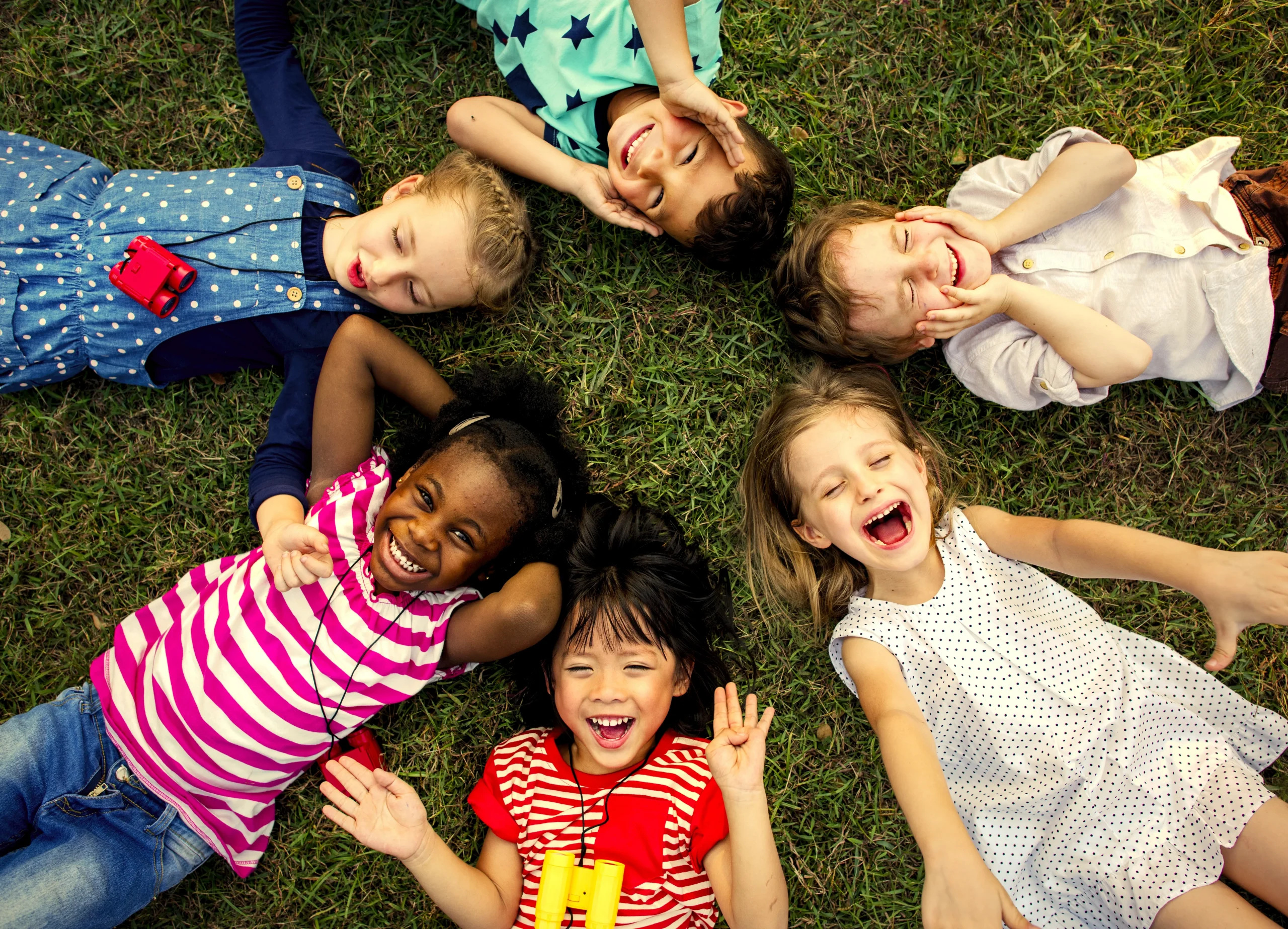 kids laying down in grass